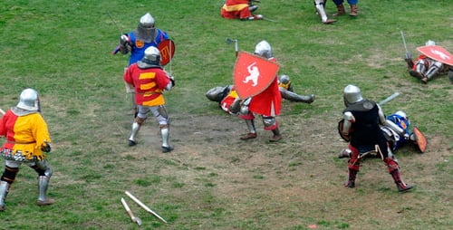 Medieval Battle Reenactment with Knights Fighting on Grass