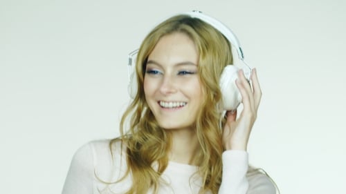 Smiling Woman Listening to Music on Headphones