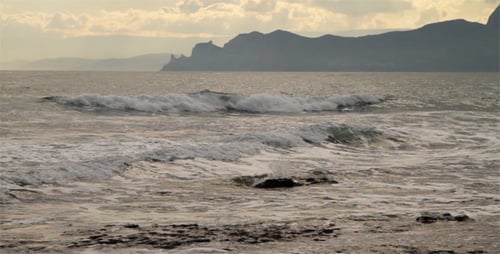 Waves Crashing on a Rocky Beach at Sunset