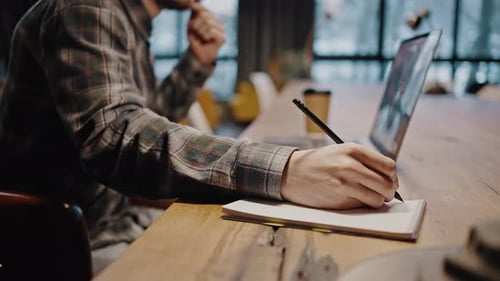 Adult Taking Notes at a Desk