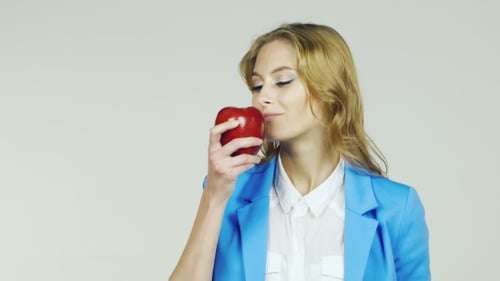 Young Woman Biting a Red Apple