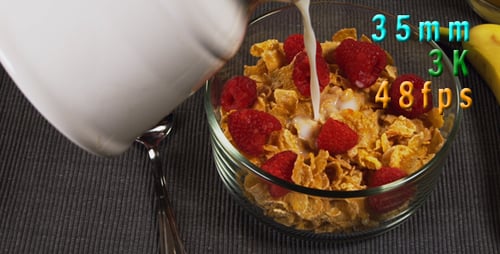 Pouring Milk onto Cereal with Raspberries