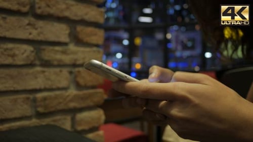 Hands Typing on Mobile Phone at Night