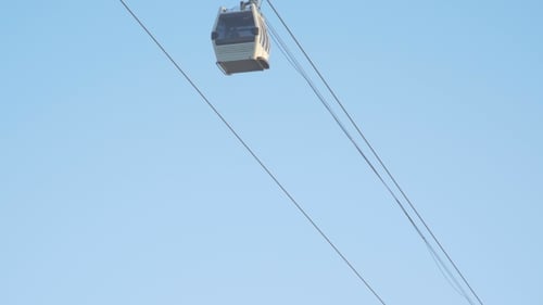 Cable Car Travels Upward Against Blue Sky