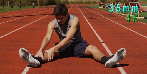 Male Stretching Legs on Outdoor Running Track