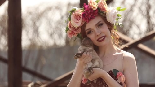 Woman Holds Rabbit Wearing Flower Crown Outdoors