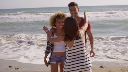 Friends Posing and Embracing on Sunny Beach