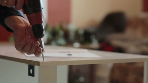 Man Assembling Furniture with Drill at Home