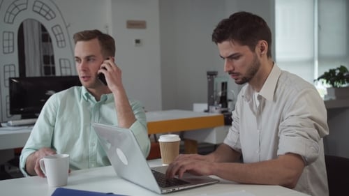 Deux jeunes hommes d'affaires travaillant au bureau moderne