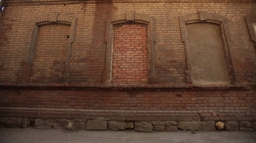 Girl In a Leather Jacket And Boots Posing In a Red Brick Wall