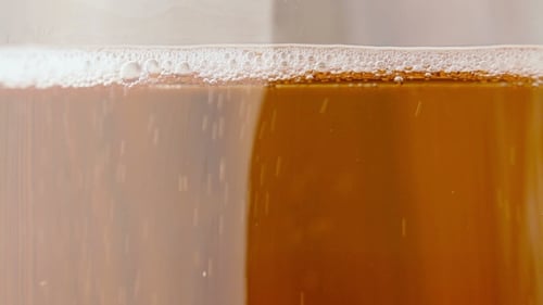 Amber Colored Liquid with Bubbles in Glass