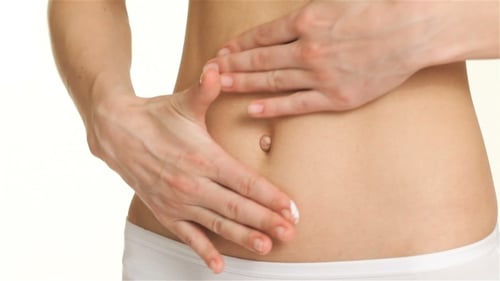 Von Frau cremt ihren Bauch