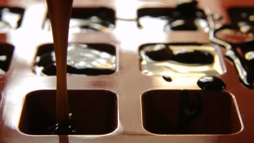 Pouring Melted Dark Chocolate into Silicone Mold