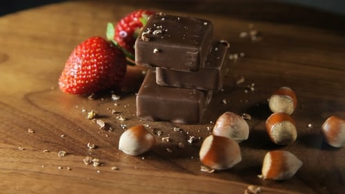 Chocolate, Strawberries, and Hazelnuts on Wooden Board