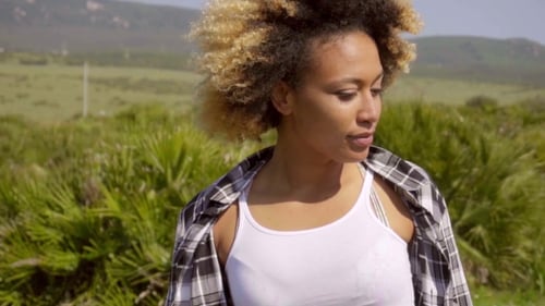 Young Adult Woman with Curly Hair Smiles Outdoors