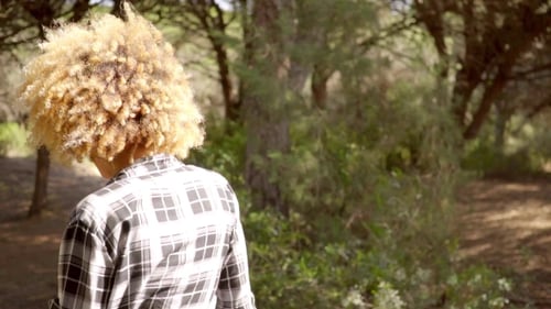 Back View Of A Walking Woman On The Forest Road.