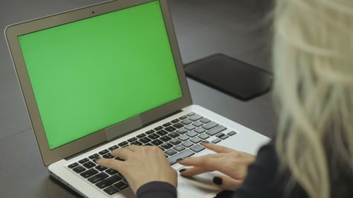 Female Hands Typing on the Laptop Keyboard. Laptop With Green Screen