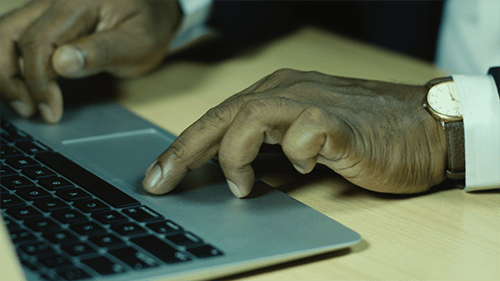 Close Up of Hands Using Laptop Trackpad