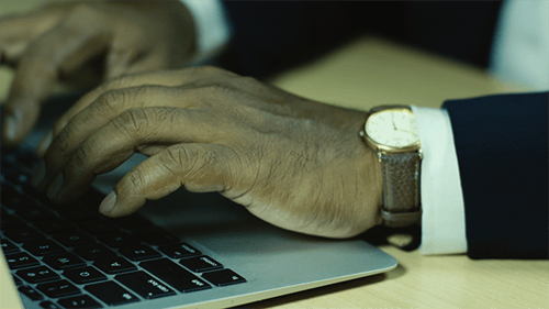 Man's Hands Typing on Laptop in Office