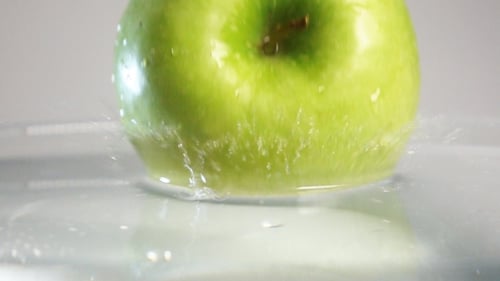 Green Apple Plunging Into Water