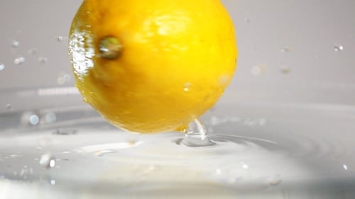 Lemon Sinking and Splashing in Water Close Up
