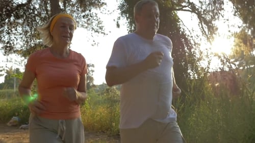 Energetic Couple Jogging Through a Sunny Nature Park