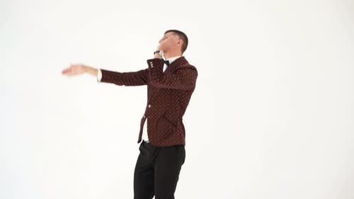Humorista de traje oscuro parodia los movimientos corporales de una persona que baila en una fiesta