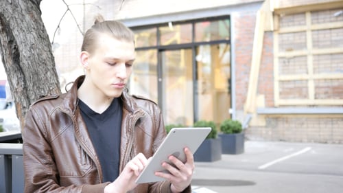 Young Adult Using Tablet in Urban Setting