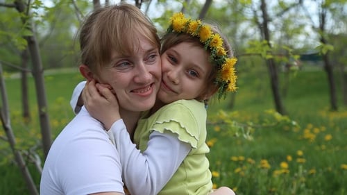 Woman and Child Embrace in Sunny Meadow