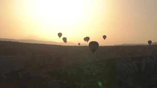 Hot Air Balloons Soaring Over Desert at Sunrise