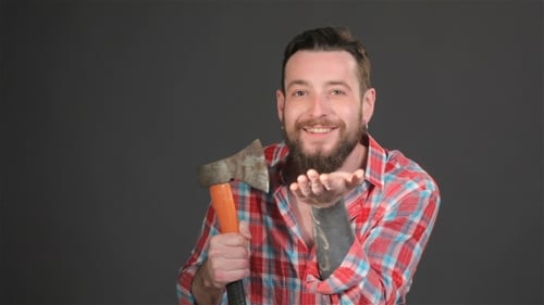 Man Smiles and Poses with an Axe