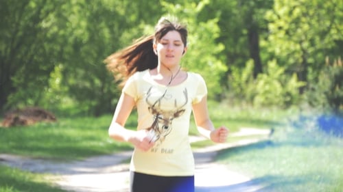 Girl Running On Forest Path In a Park And Taking Breath After Jogging.