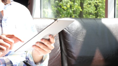 Young Adult Using Tablet Inside Near Window