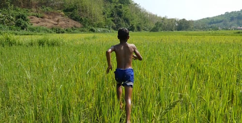 Poverty Boy Running In Grass
