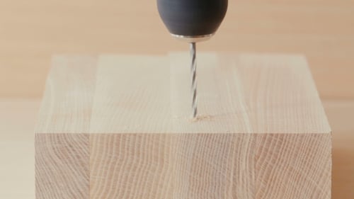 Drill Bit Drilling Into a Wooden Block