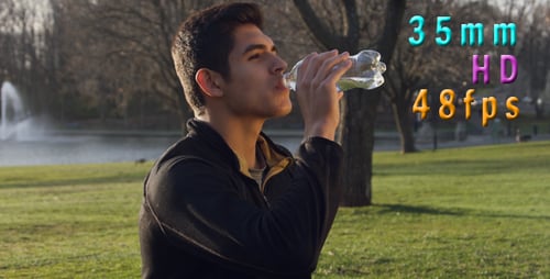 Man Drinking Water Bottle Outdoors in Park