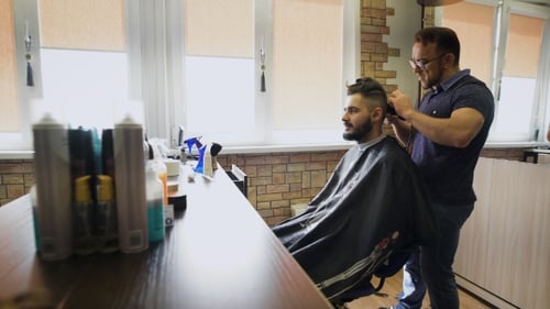 Barber Styling a Man's Hair in Salon