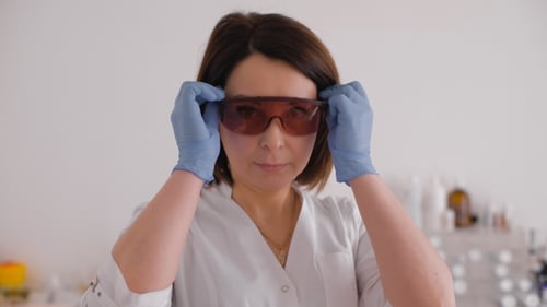 Female Doctor Putting on Protective Eyewear