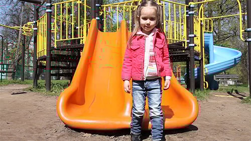 Little Girl Riding On a Slide