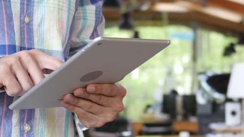 Person Holding and Using a Modern Tablet