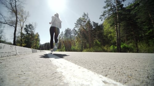 Female Runner Jogging On Mountain Road Training For Marathon.
