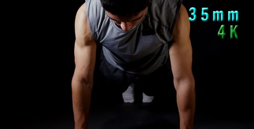 Man Doing Pushups Against Black Background