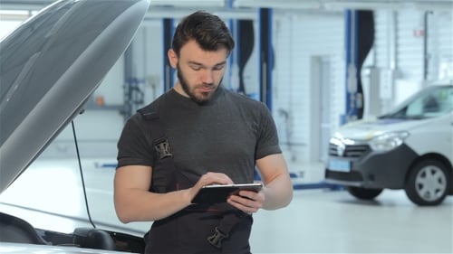 Mechaniker benutzt ein Tablet beim Autoservice