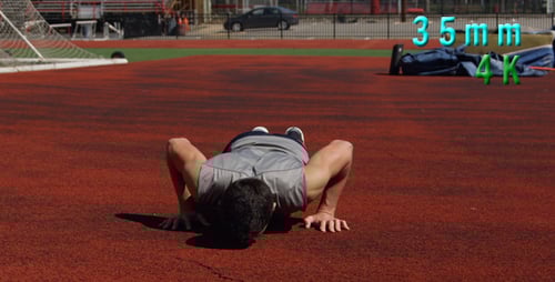 Man Doing Push-Ups on a Red Running Track