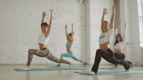Women Exercising Yoga in a Bright Studio