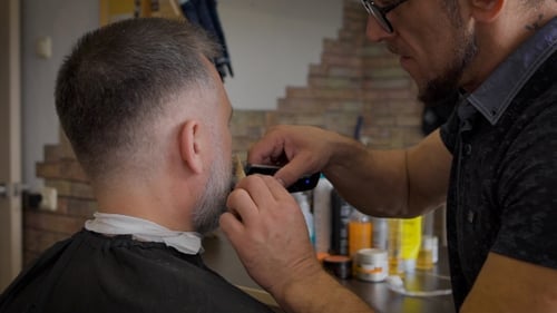 Man Trimming Beard at a Barbershop with Razor