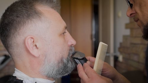 Barber Trims a Gray Beard with Clippers