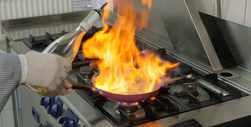 Chef Flambéing Food on a Gas Stove