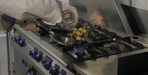Chef Prepares Food with Flames in Commercial Kitchen