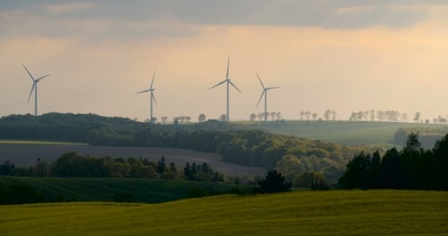 Wunderschöne Windmühlen-Turbinen, im Sonnenuntergang silhouettierte Windenergie.